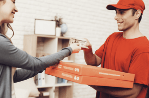 Delivery person delivering pizza to a client