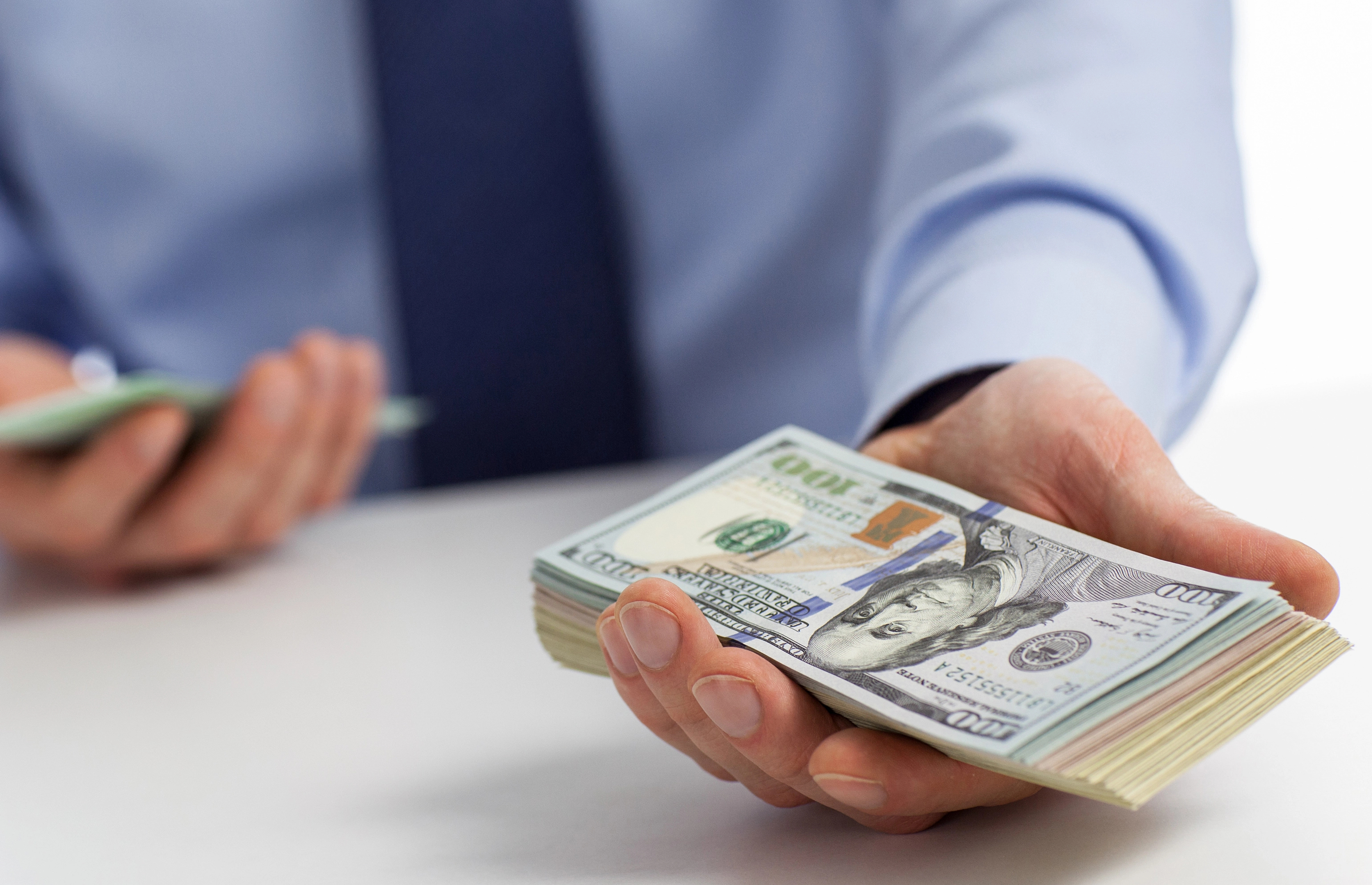 A person holding dollar bills