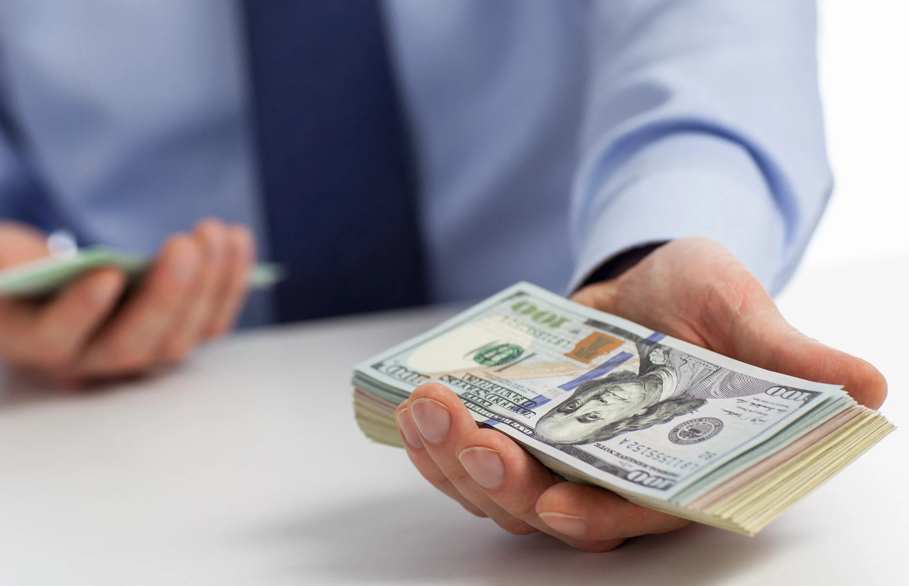 A person holding a bundle of cash