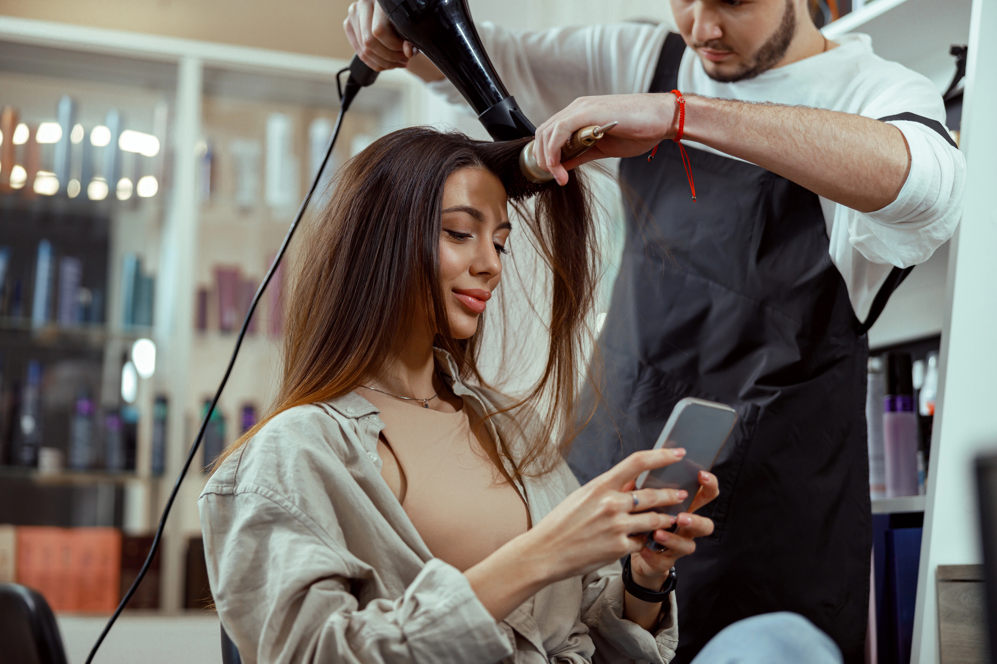 solo salon owner giving the client a lesson on how to use a blow dryer properly