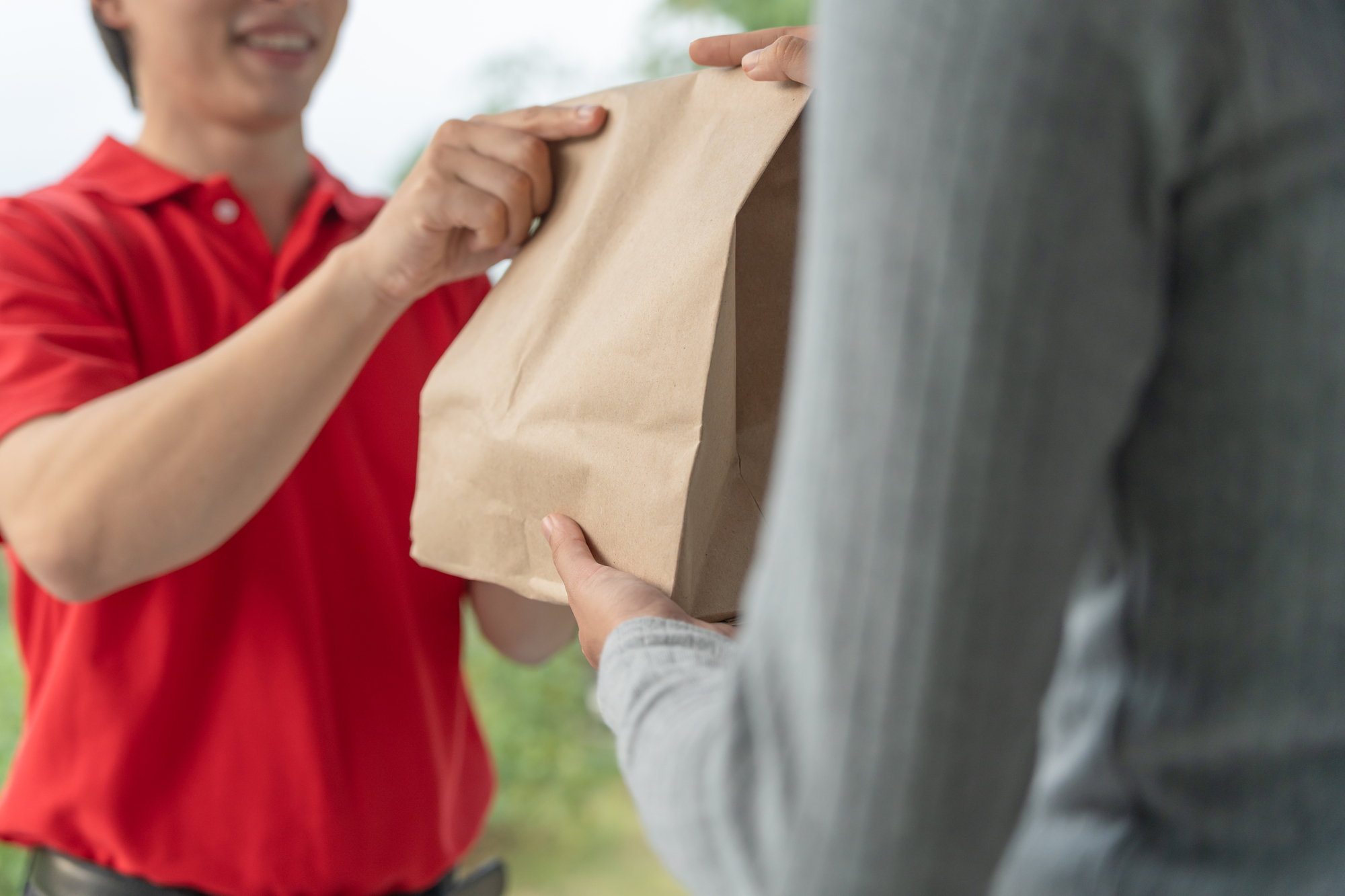 DoorDash driver with a bright smile delivering food to a customer