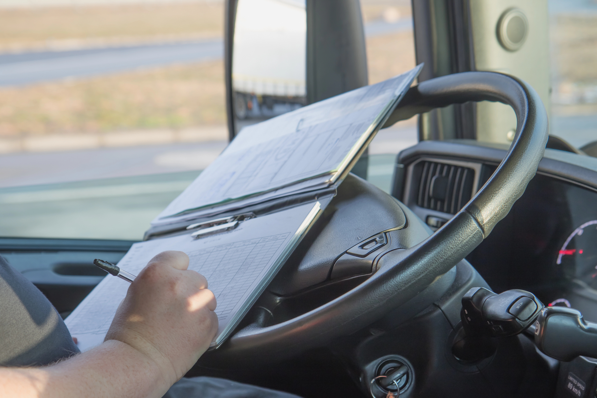 truck driver checking their pay stub and list of deliveries