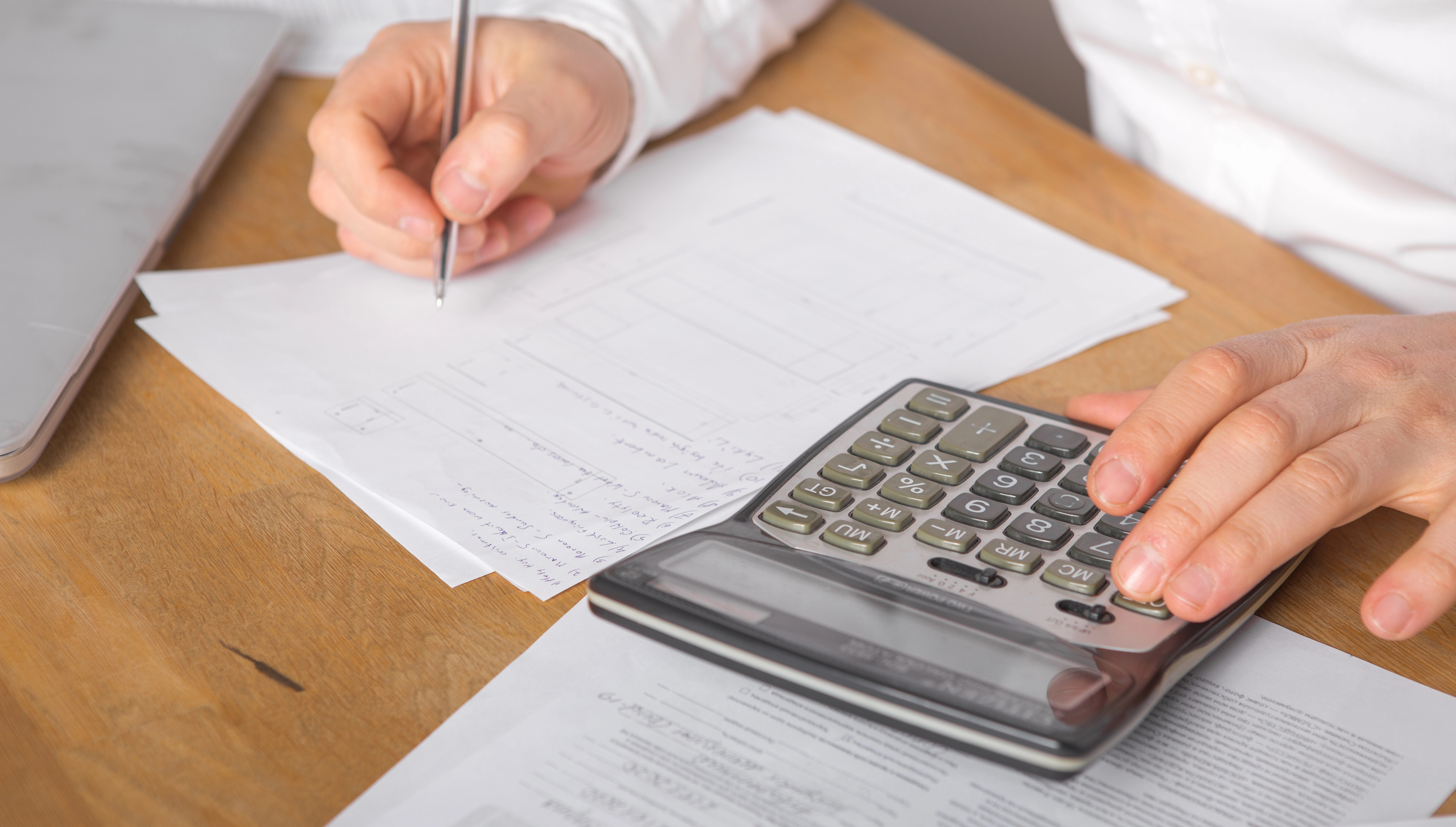 A person writing and calculating finances