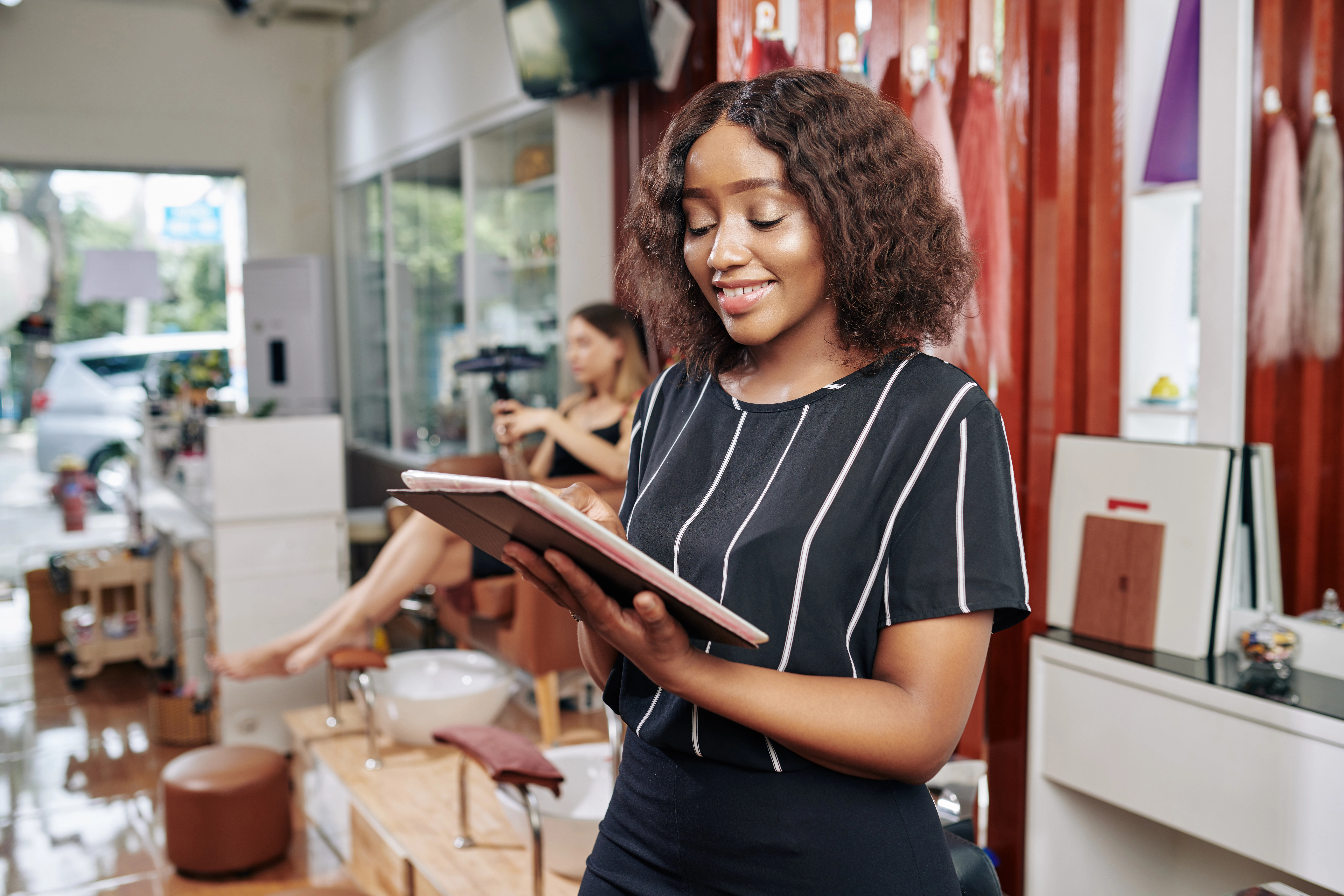 A salon owner looking at a tablet.