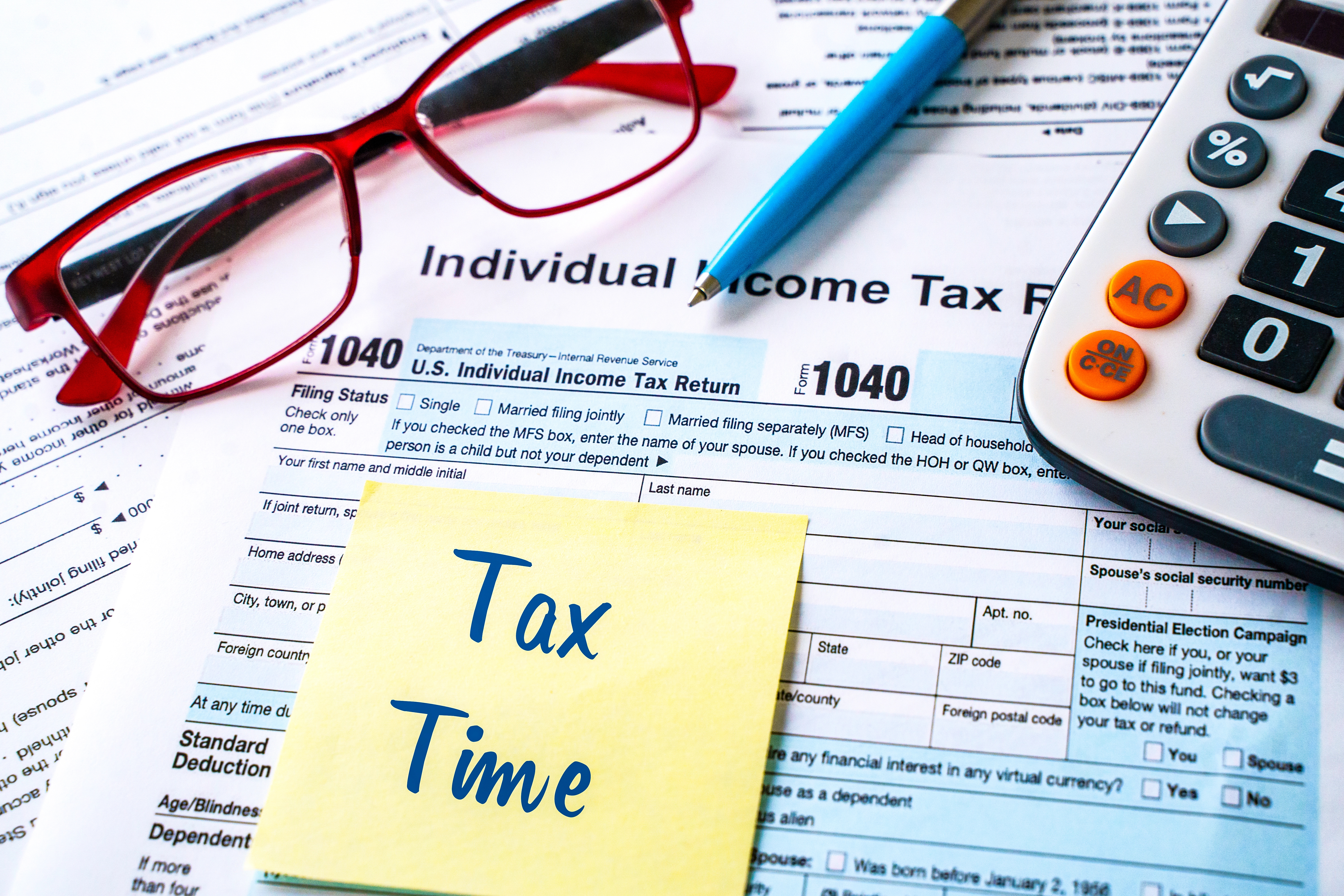 A tax form with a sticky note that says tax time.