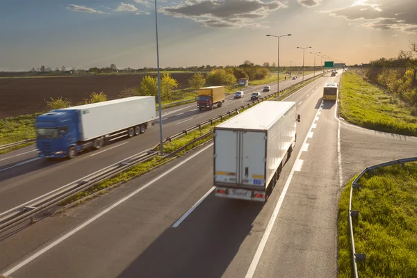 two lane highway where multiple trucks are passing by