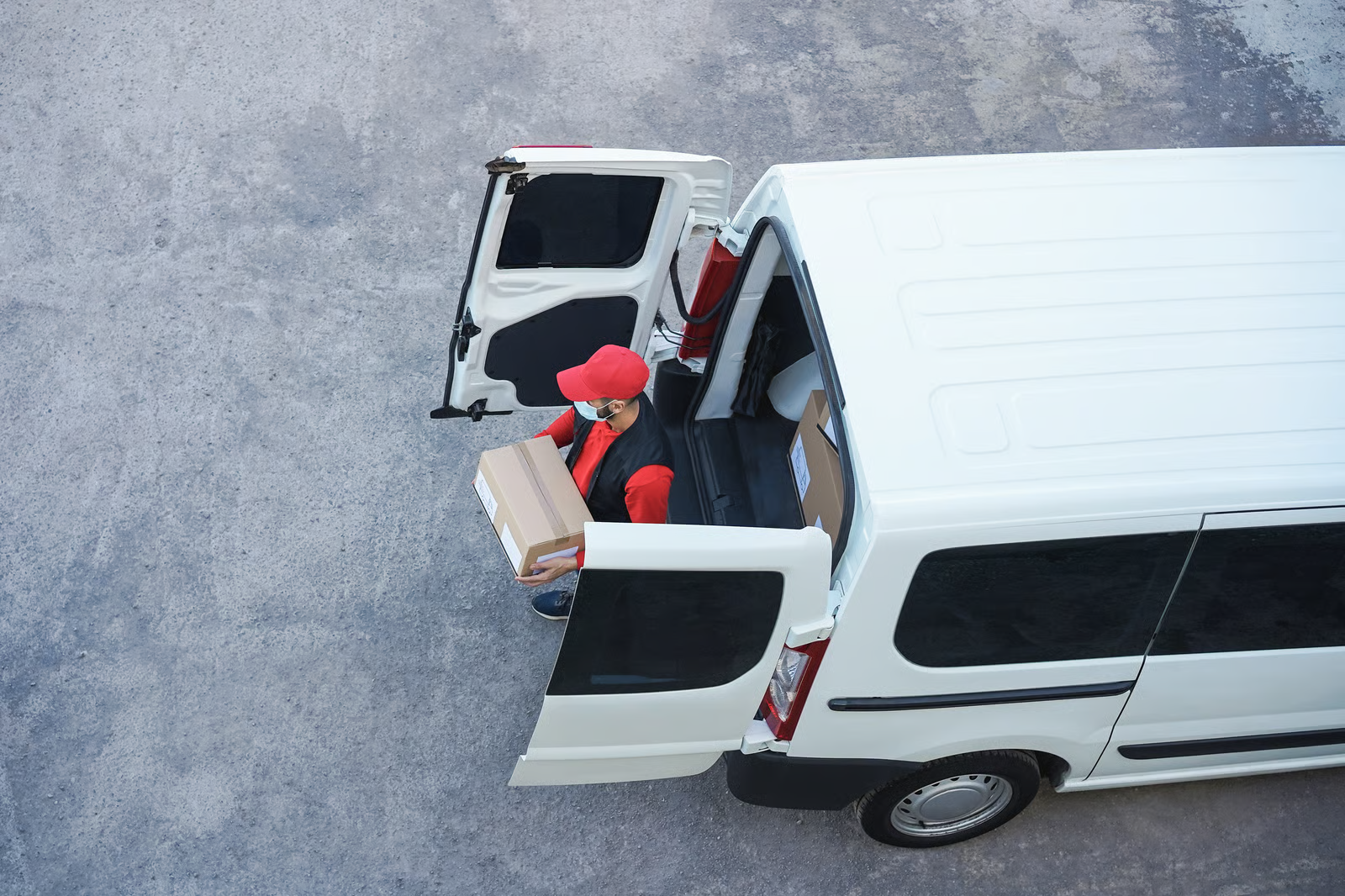 Delivery driver unloading packages from a van