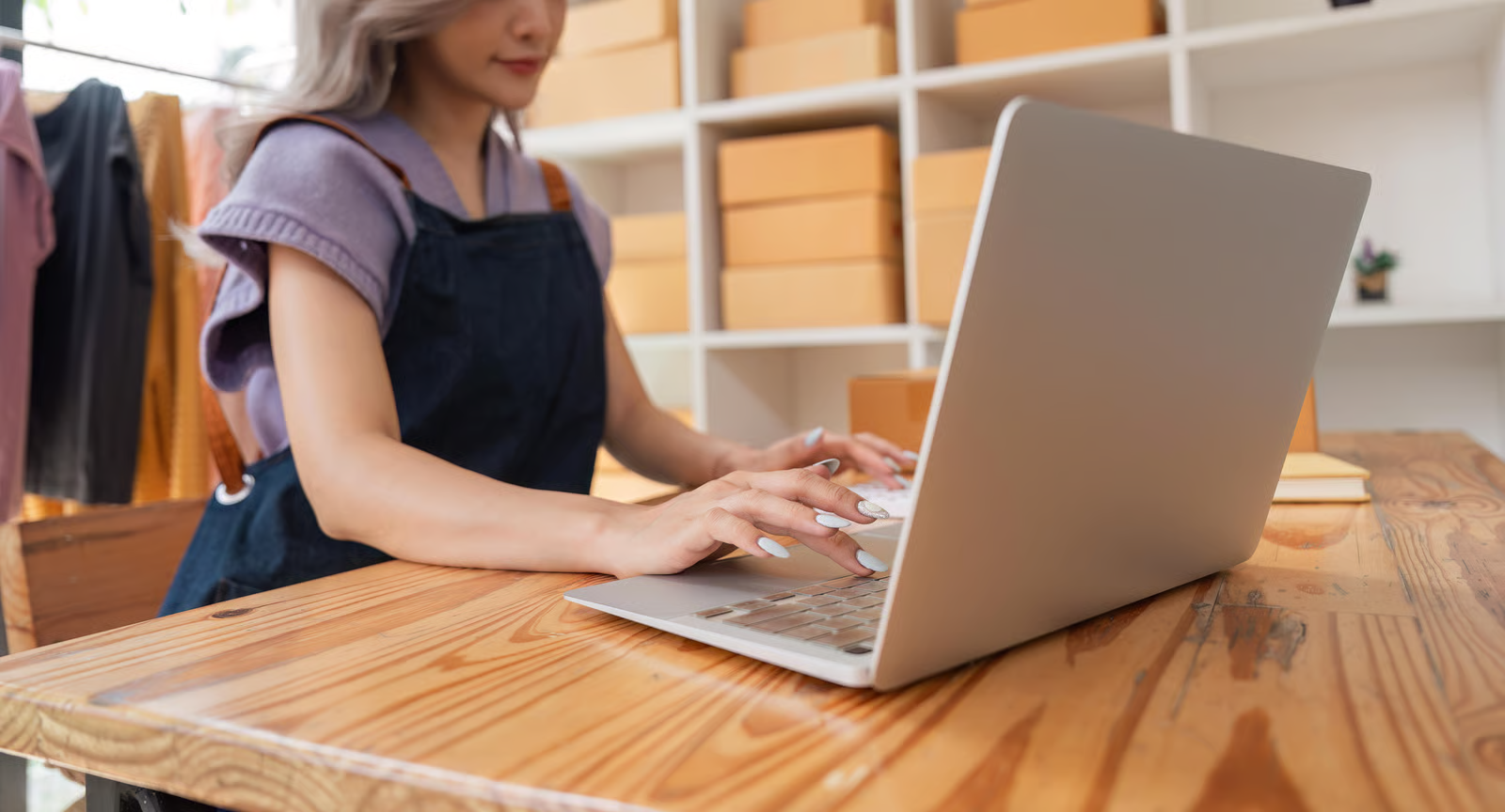  Small business owner working on a laptop at a desk, reviewing financial reports