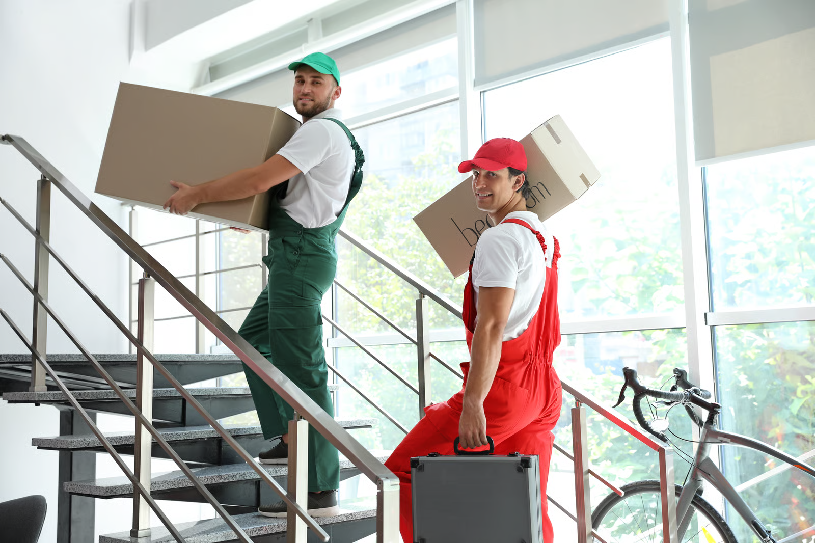 small moving business owner with a new hire carrying boxes upstairs