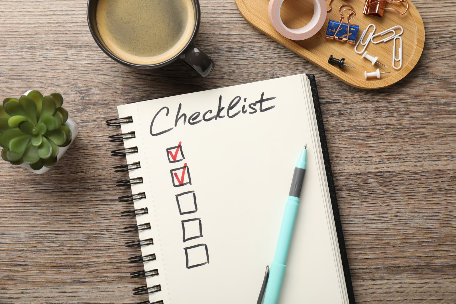 a notebook with a checklist placed on top of a wooden table
