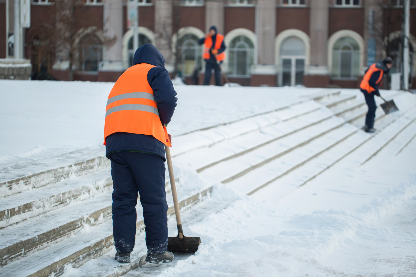 gig workers shovelling snow as part of their winter side hustle