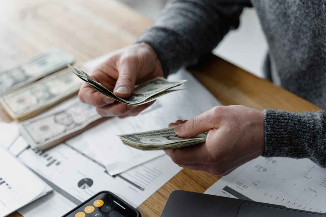 Gig worker counting the money they receive after finishing a one-off freelance project
