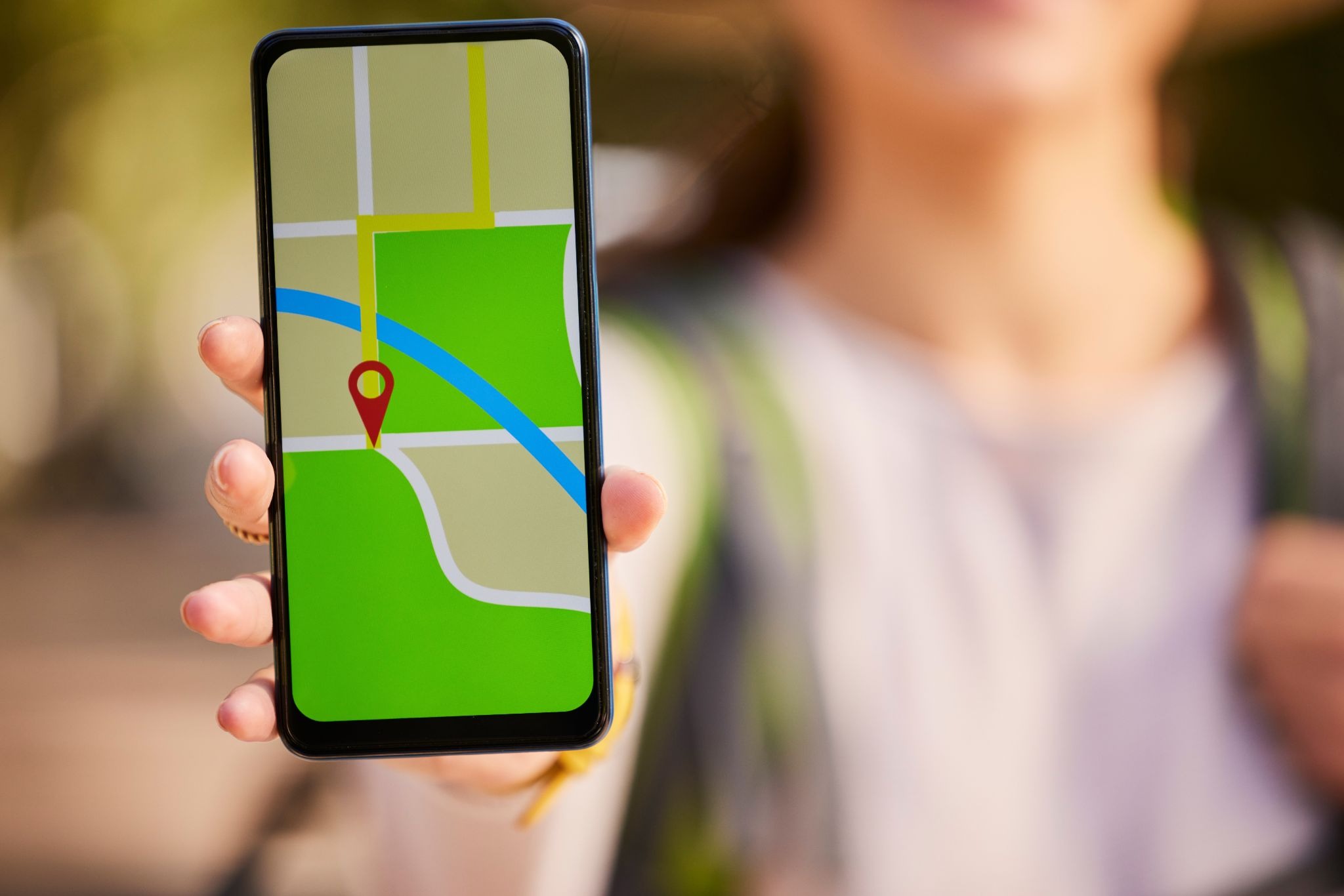 A person holding a phone showing a gps on the screen