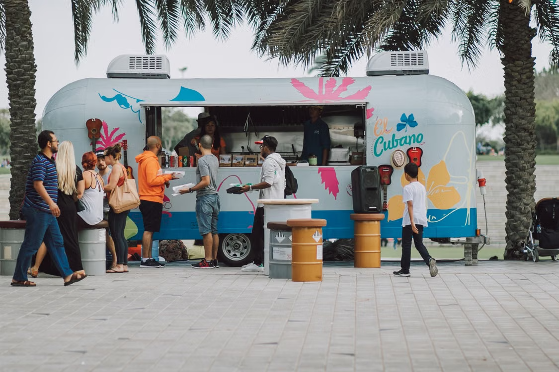A line of customers waiting to order at an independent food truck's window