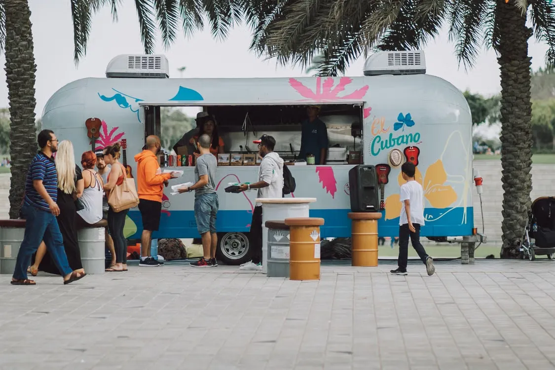 A line of customers waiting to order at an independent food truck's window