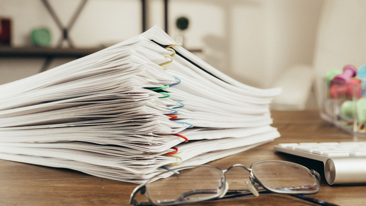Neatly arranged stacks of documents with colorful paperclips, placed on a tabletop