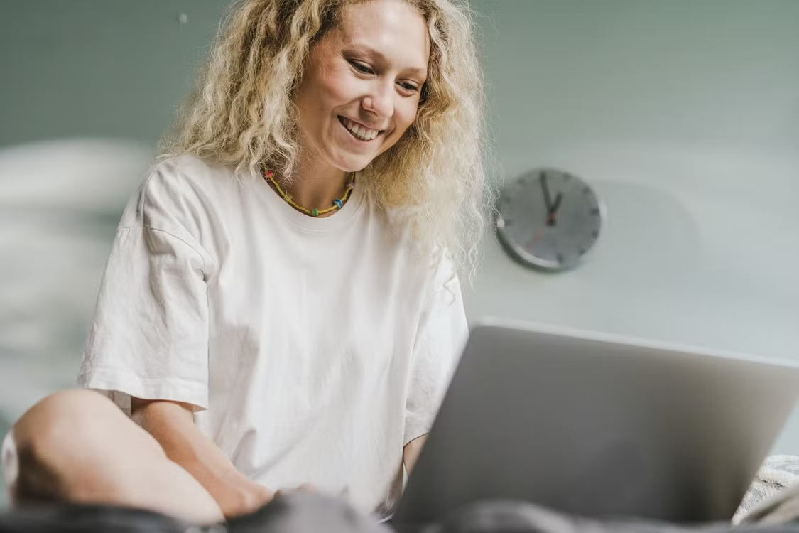 Freelancer smiling with relief while using a laptop, reassured that their banking details are secure