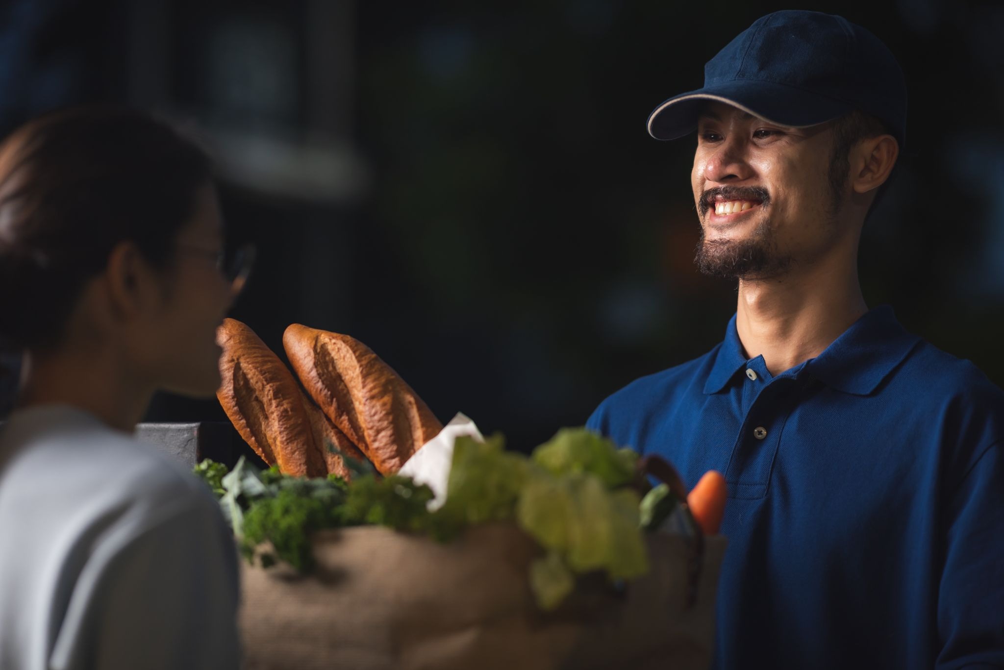Gopuff delivery driver completing a grocery delivery to a customer's doorstep