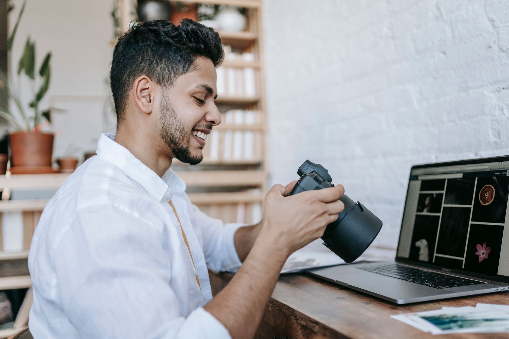 Photographer reviewing images on a camera before transferring them to a laptop 