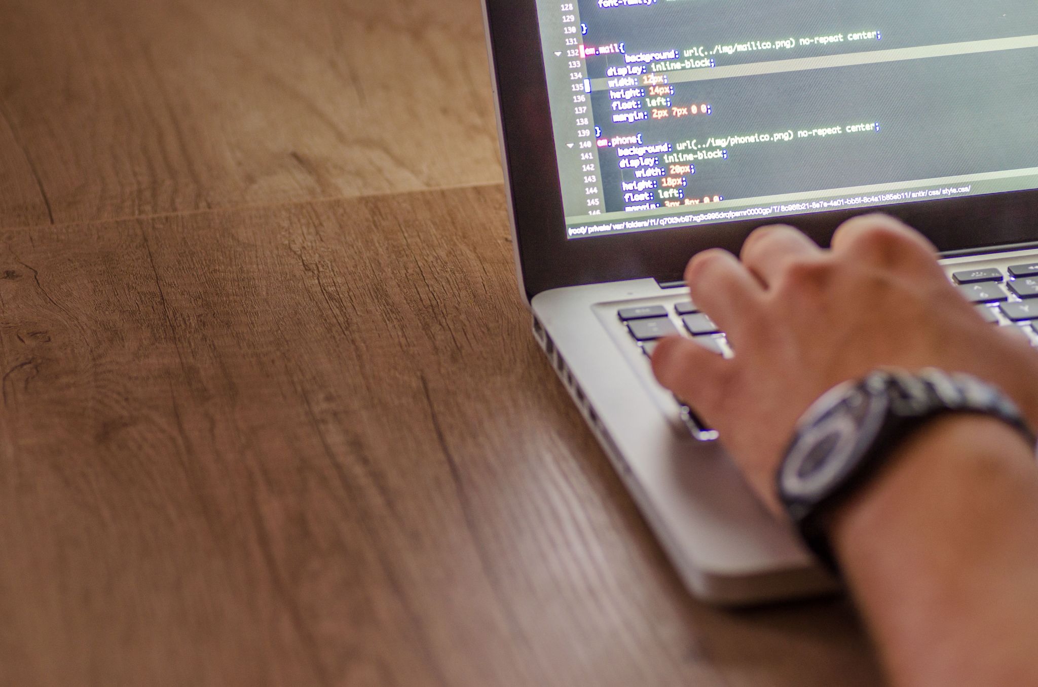 Remote web developer working on website code from a home workspace