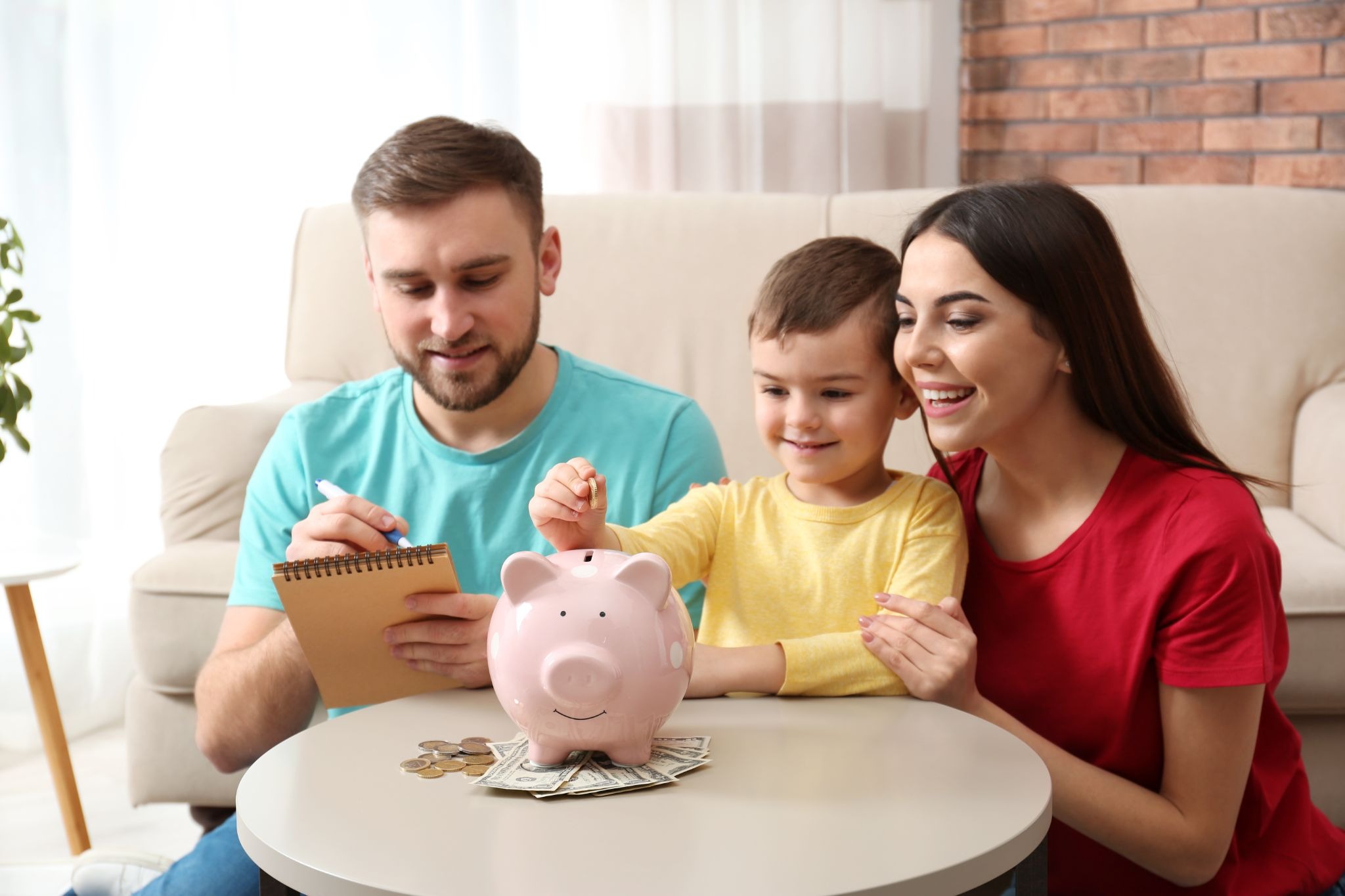 Gig worker creating a family budget with their partner while teaching their child the importance of saving money for future financial goals