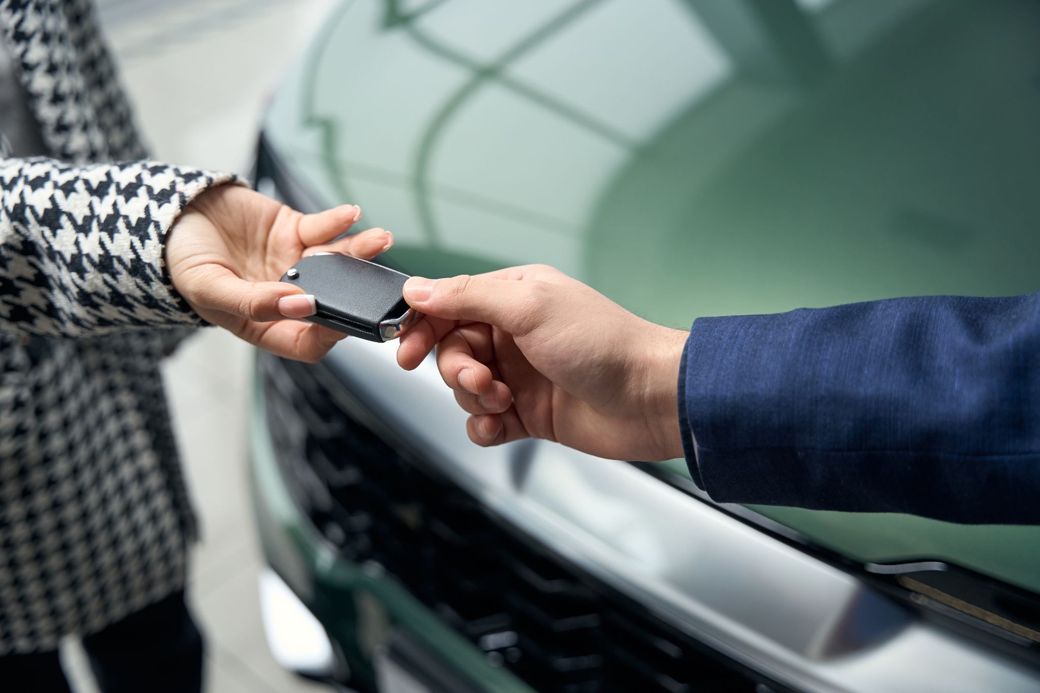 Car owner handing over keys to a renter, earning extra income by sharing a personal vehicle