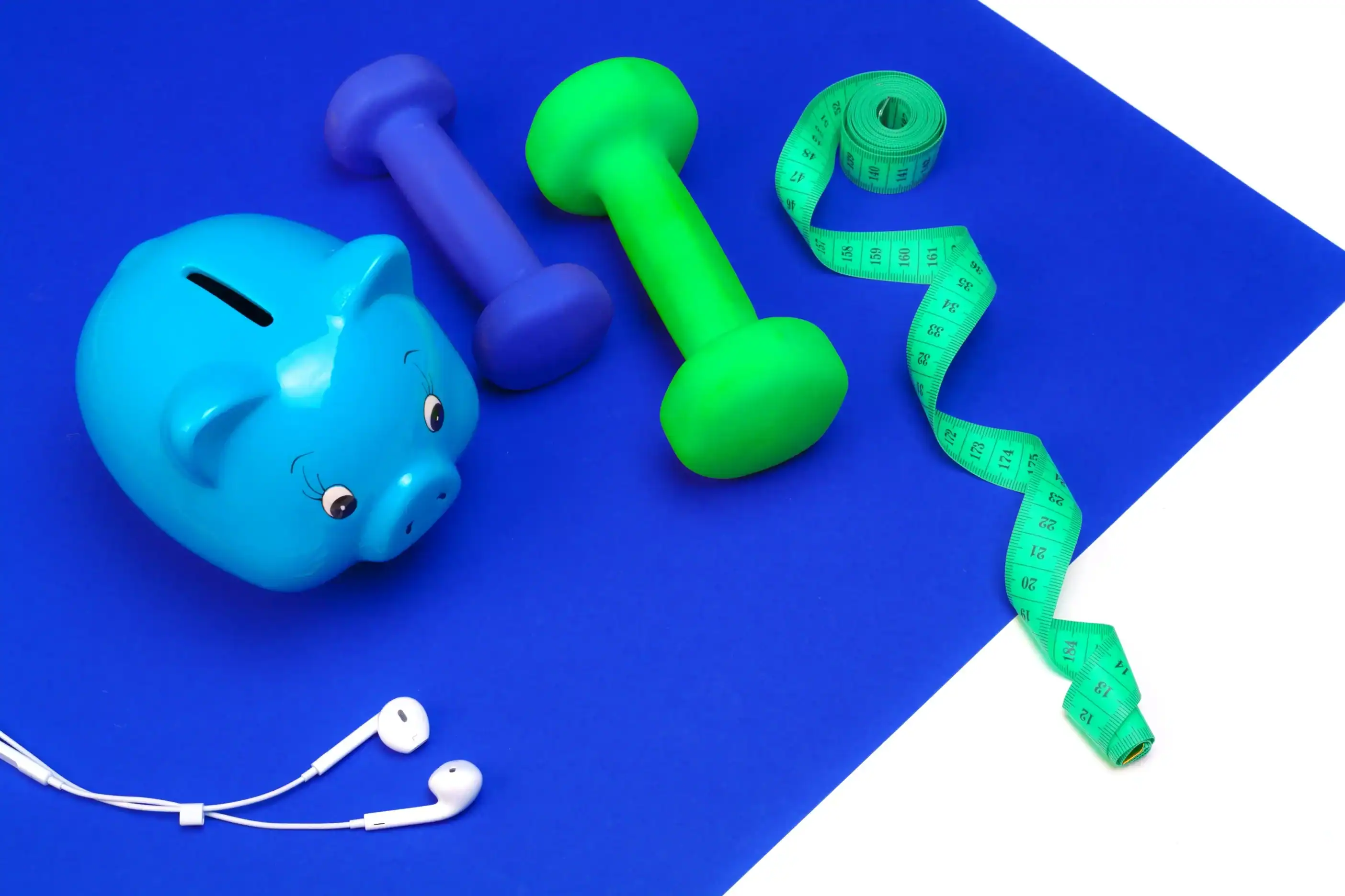 Piggy bank and fitness equipment representing fixed business costs for fitness professionals.