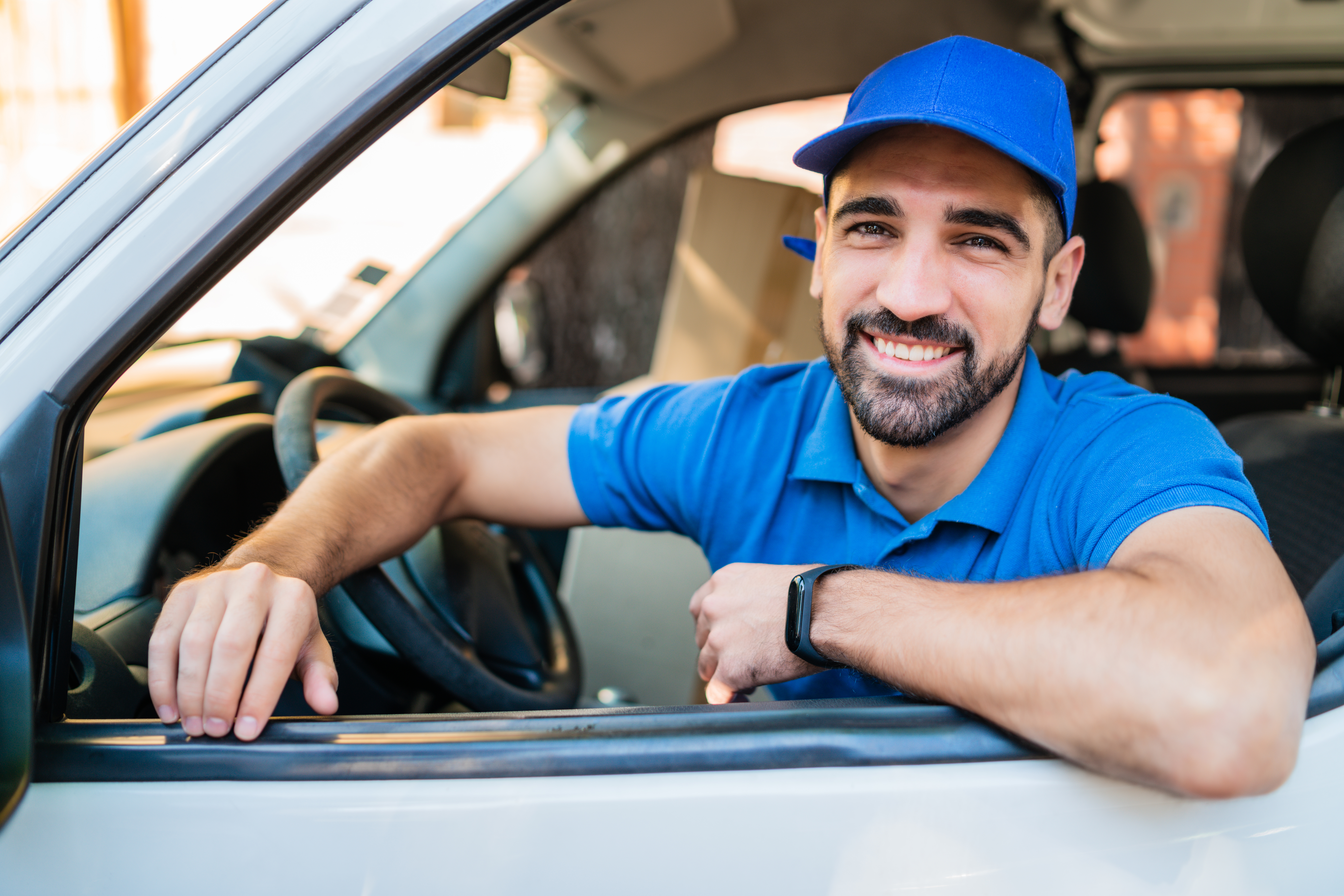 Spark Driver smiling from their delivery vehicle while preparing to complete grocery deliveries and earn flexible income.