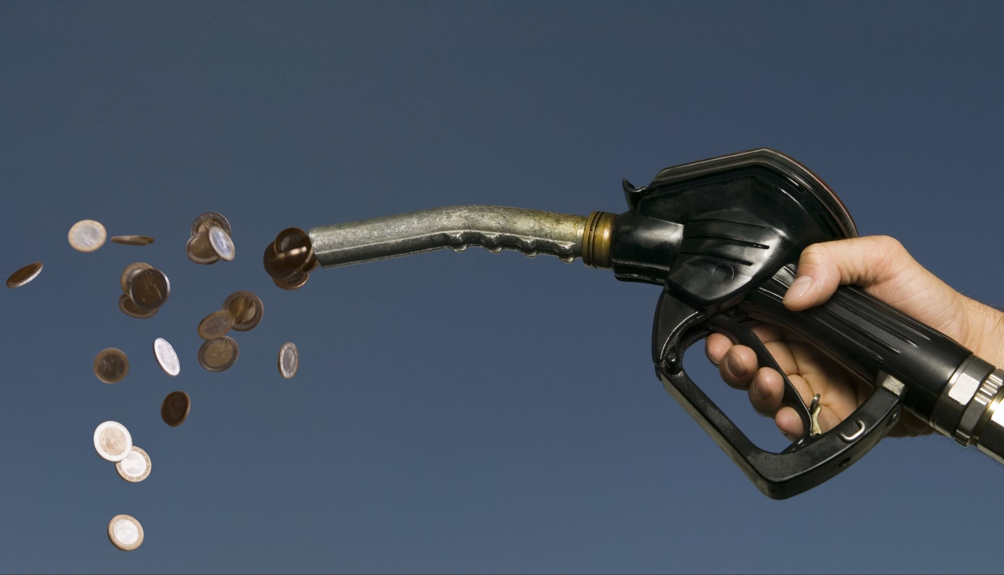 Fuel pump nozzle with falling coins representing rising fuel costs and budgeting challenges for Uber Eats drivers and other delivery gig workers.