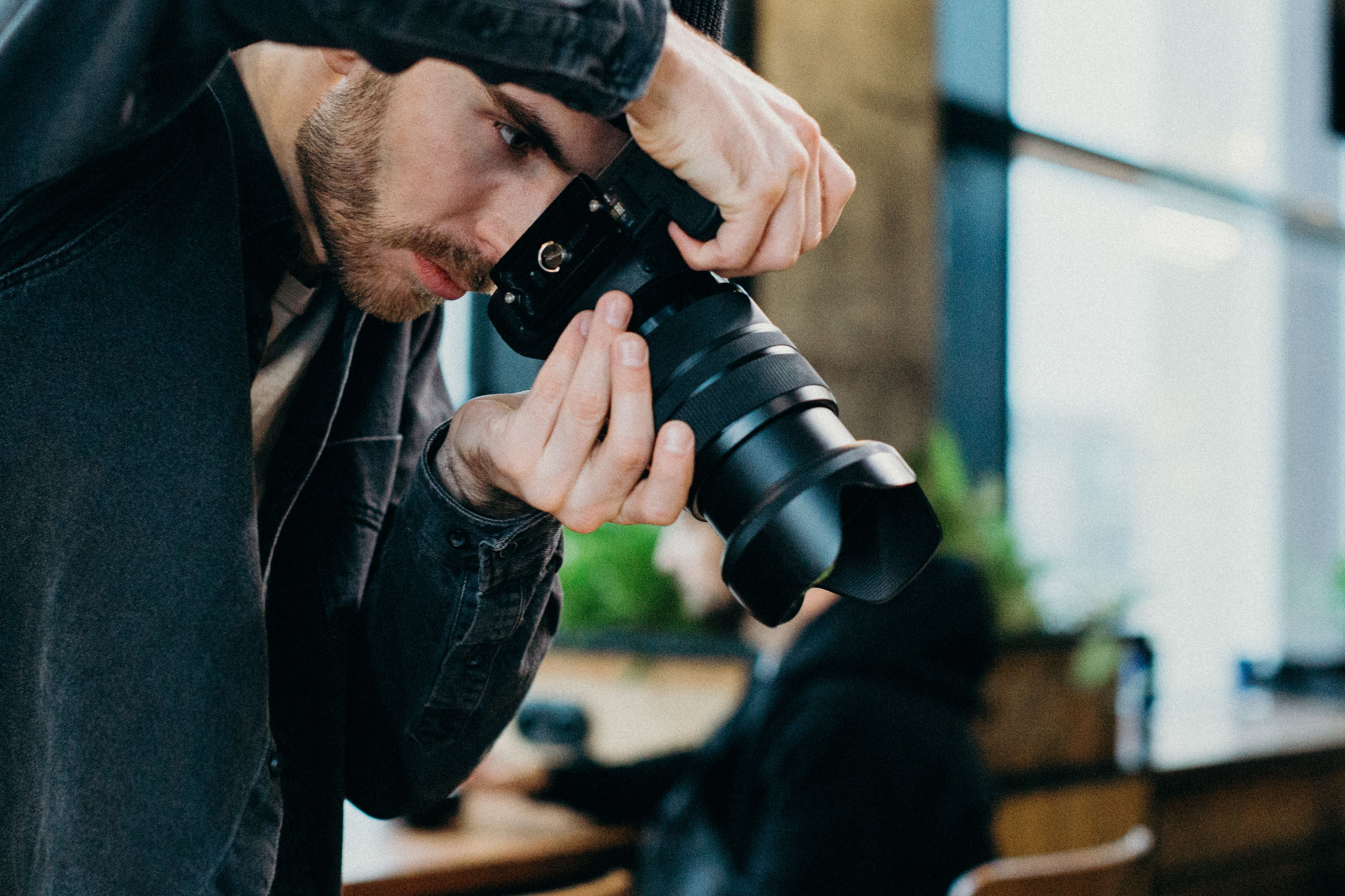 Freelance photographer getting ready to take a photo with a camera inside a studio