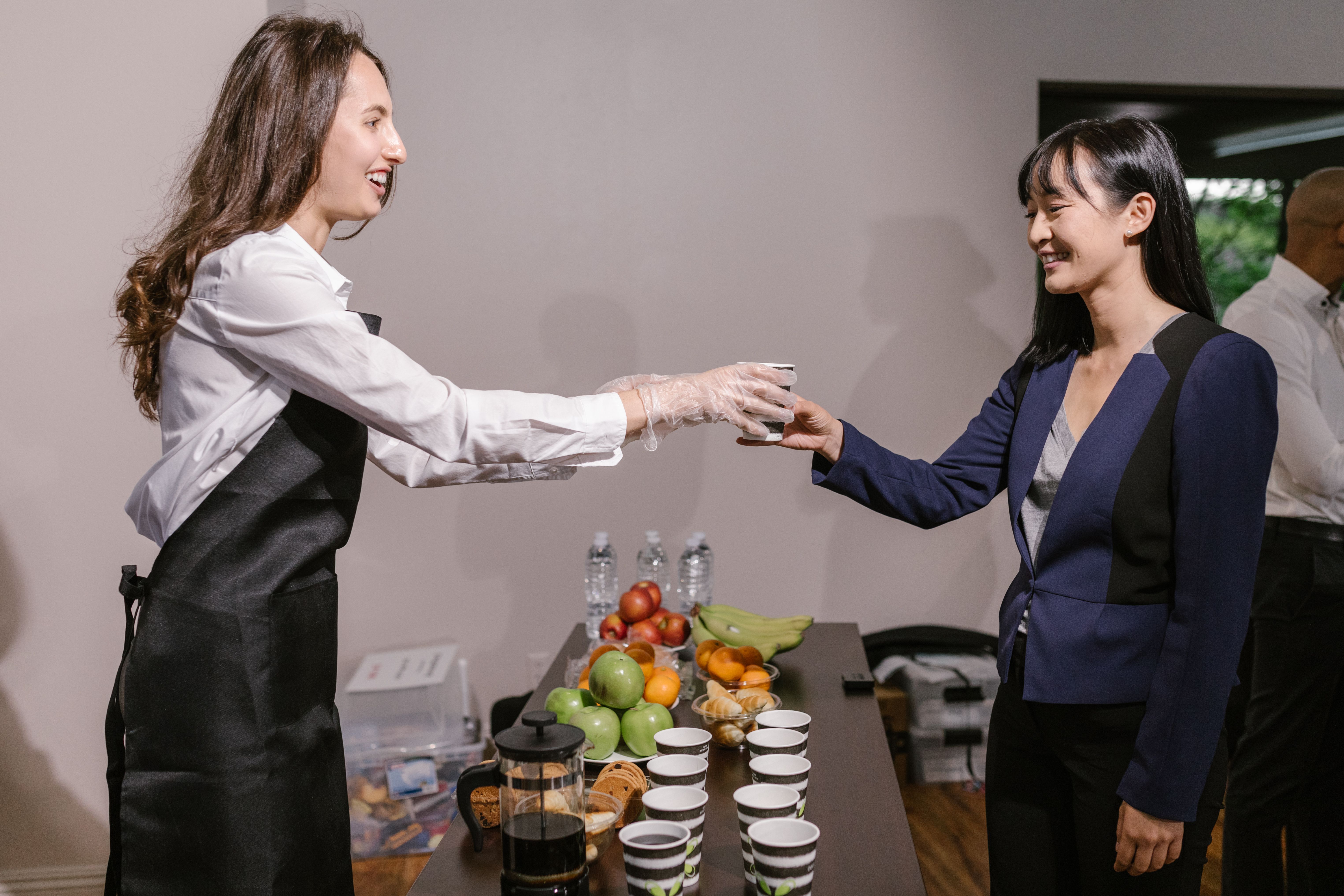 Event planner tasting a beverage sample at a food expo to evaluate options for a client