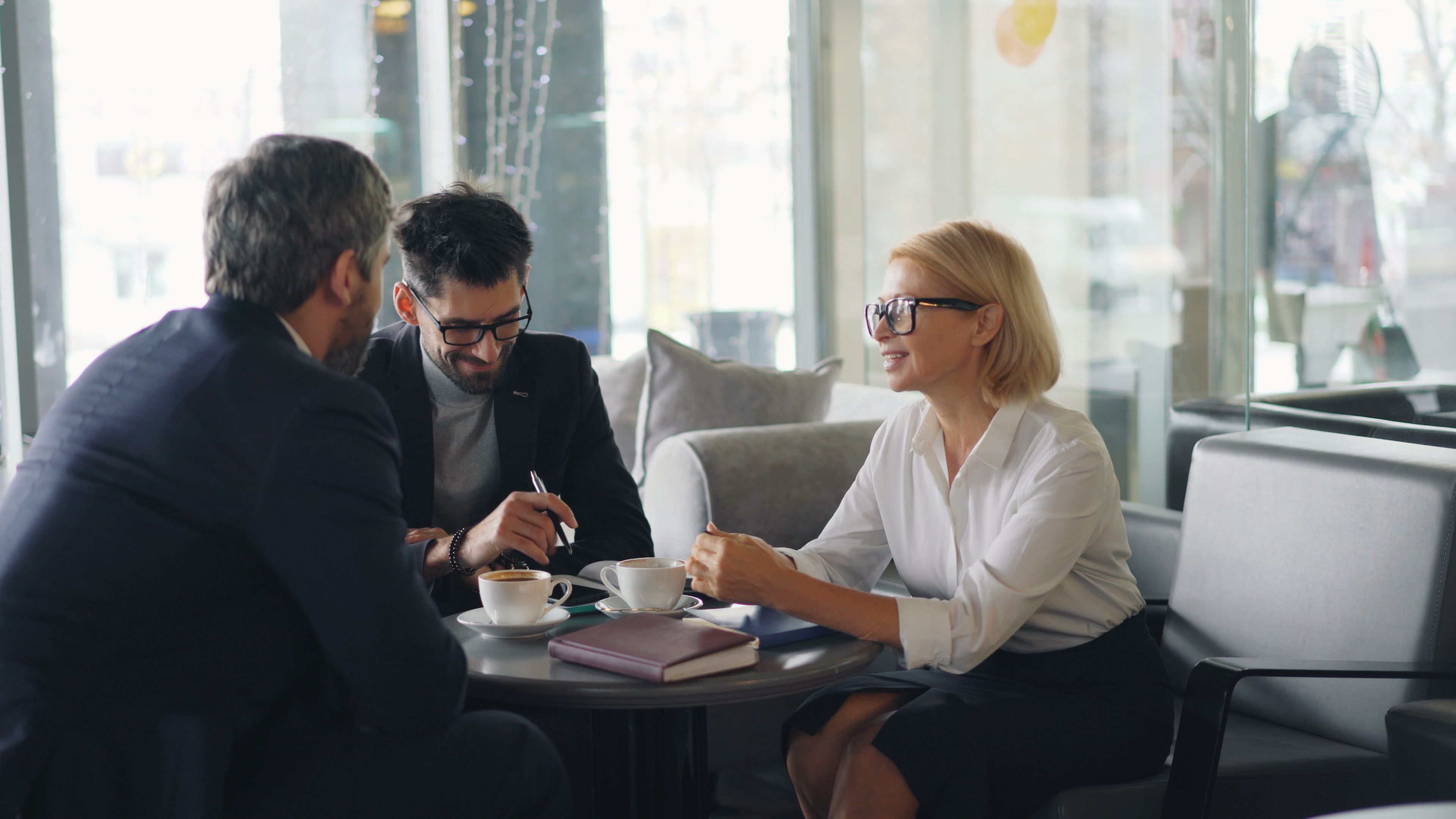 An independent consultant meets with potential clients over coffee to discuss business opportunities