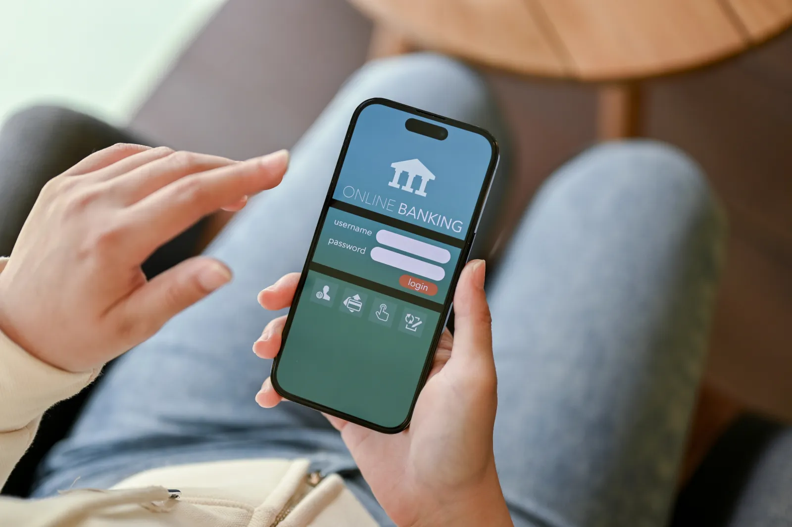 A person holding a phone showing a mobile banking app