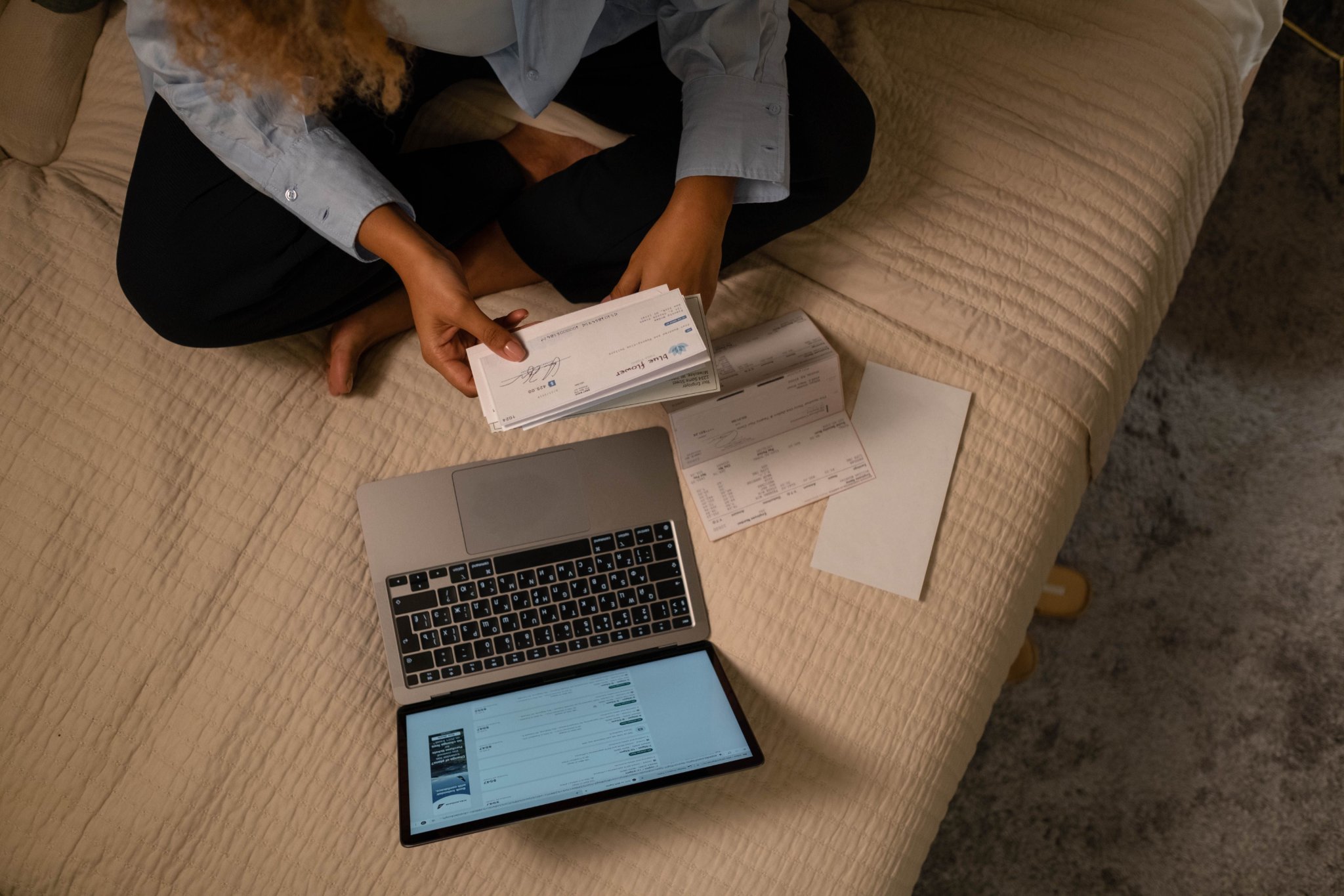 Freelance bookkeeper reviewing online banking activity and cross-checking credit card bills on their phone.