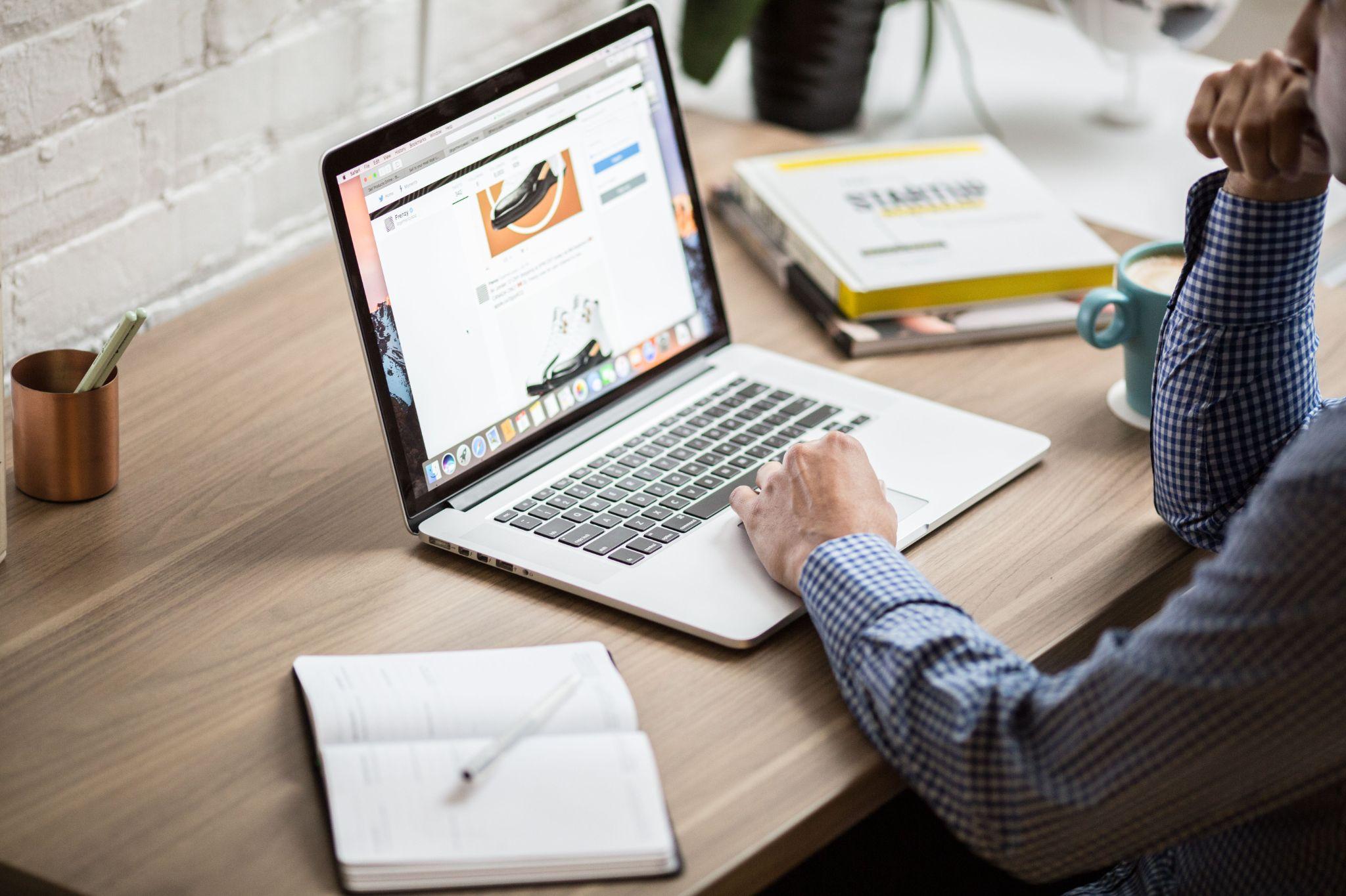 Freelance social media manager reviewing a client’s social media feed on a laptop while working at a desk