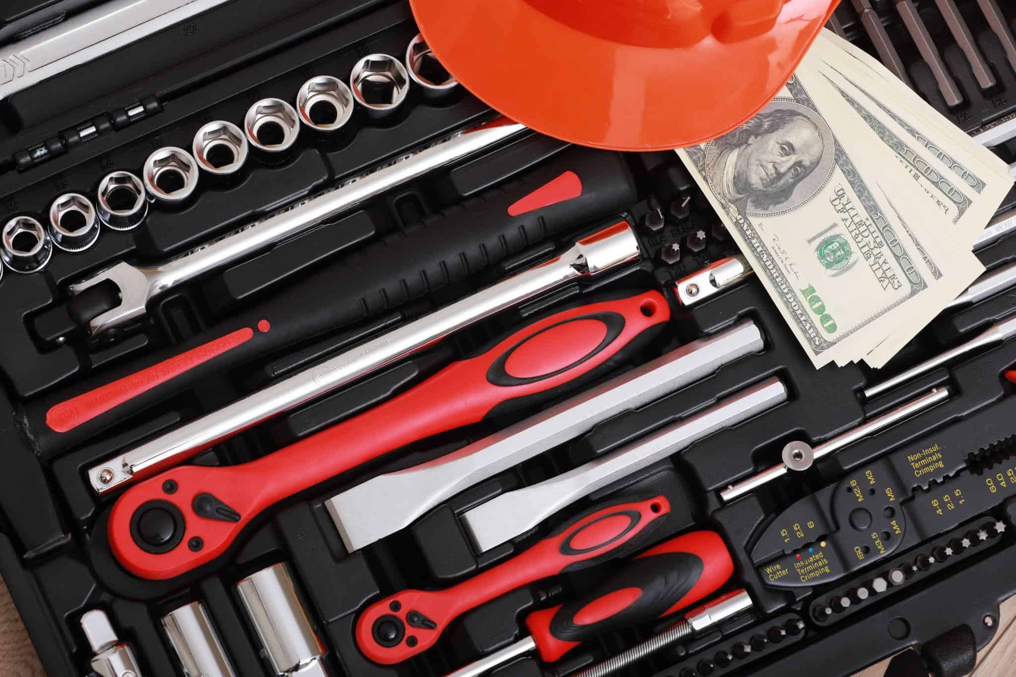 Toolbox with hand tools, a hard hat, and cash, representing a TaskRabbit tasker investing in essential equipment.