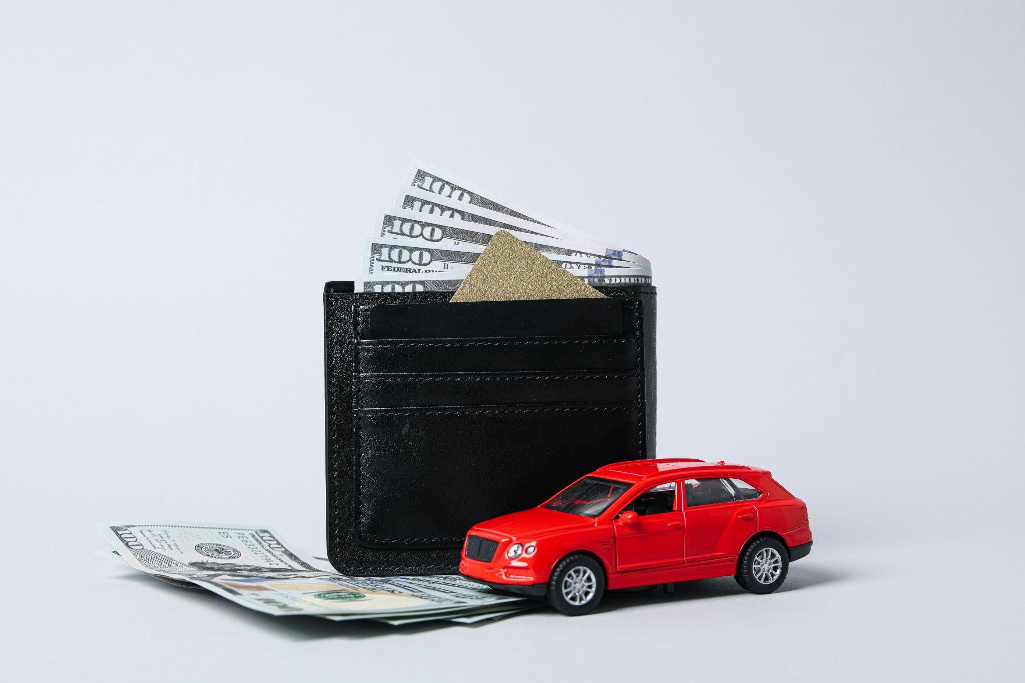 Wallet, cash, and toy car representing the costs of adding a vehicle to a Turo fleet.